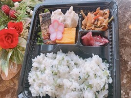 A bento box with rice, fish, tofu, and vegetables.
