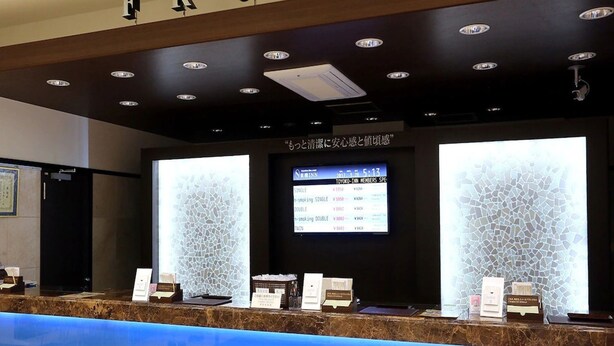 A reception desk with a digital display, a "FRONT" sign above, and a decorative wall with a mosaic pattern. - Toyoko Inn Shizuoka Shimizu Ekimae (Shizuoka)