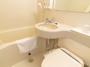 A bathroom with a white sink, toilet, and bathtub. There is a towel hanging on the wall and a cup on the edge of the bathtub. - Toyoko Inn Shizuoka Shimizu Ekimae (Shizuoka)