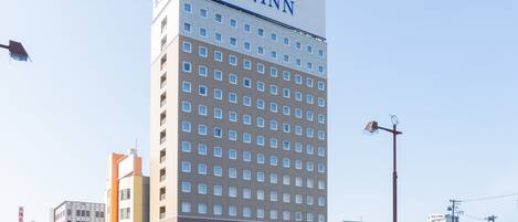 Ein hohes Hotelgebäude mit einem Schild für Toyoko Inn.