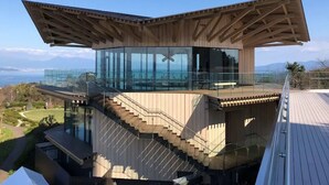 A modern building with a glass enclosure, wooden deck, and a staircase leading to an upper level. - Toyoko Inn Shizuoka Shimizu Ekimae (Shizuoka)