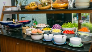 Un buffet proposant divers plats et des récipients remplis de nourriture, le tout disposé sur un comptoir.