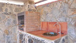 A stone wall with a brick oven and a sink. - Perfect house for families with pool (CONIL DE LA FRONTERA)