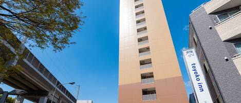 A tall building with a sign for 'Toyoko Inn' on the side.