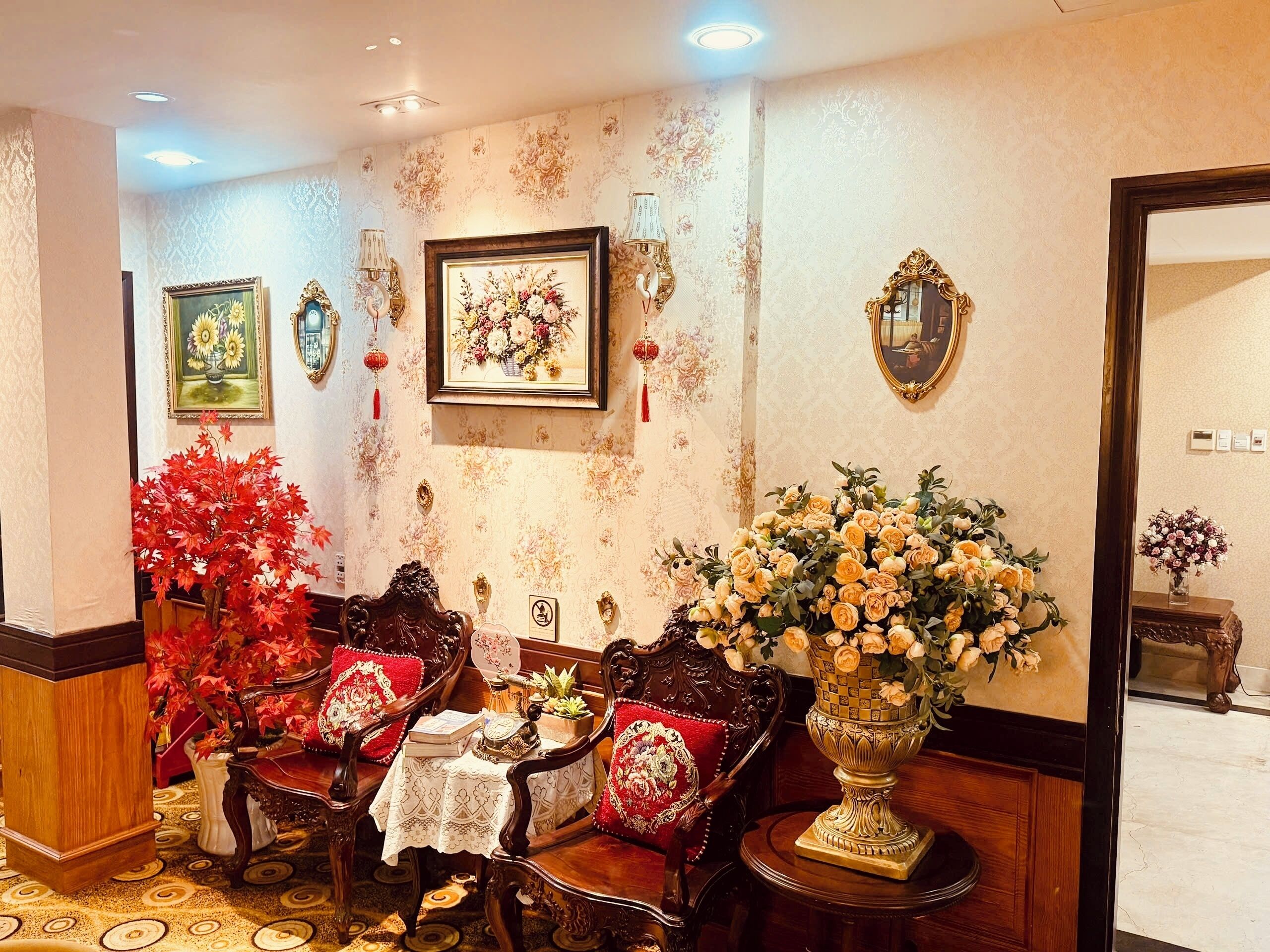 A traditional room with ornate furniture, floral decorations, and a classic design.
