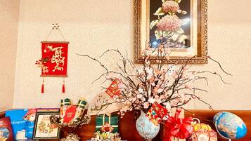 A table with various items including a vase with branches, a framed painting, and several wrapped gifts.
