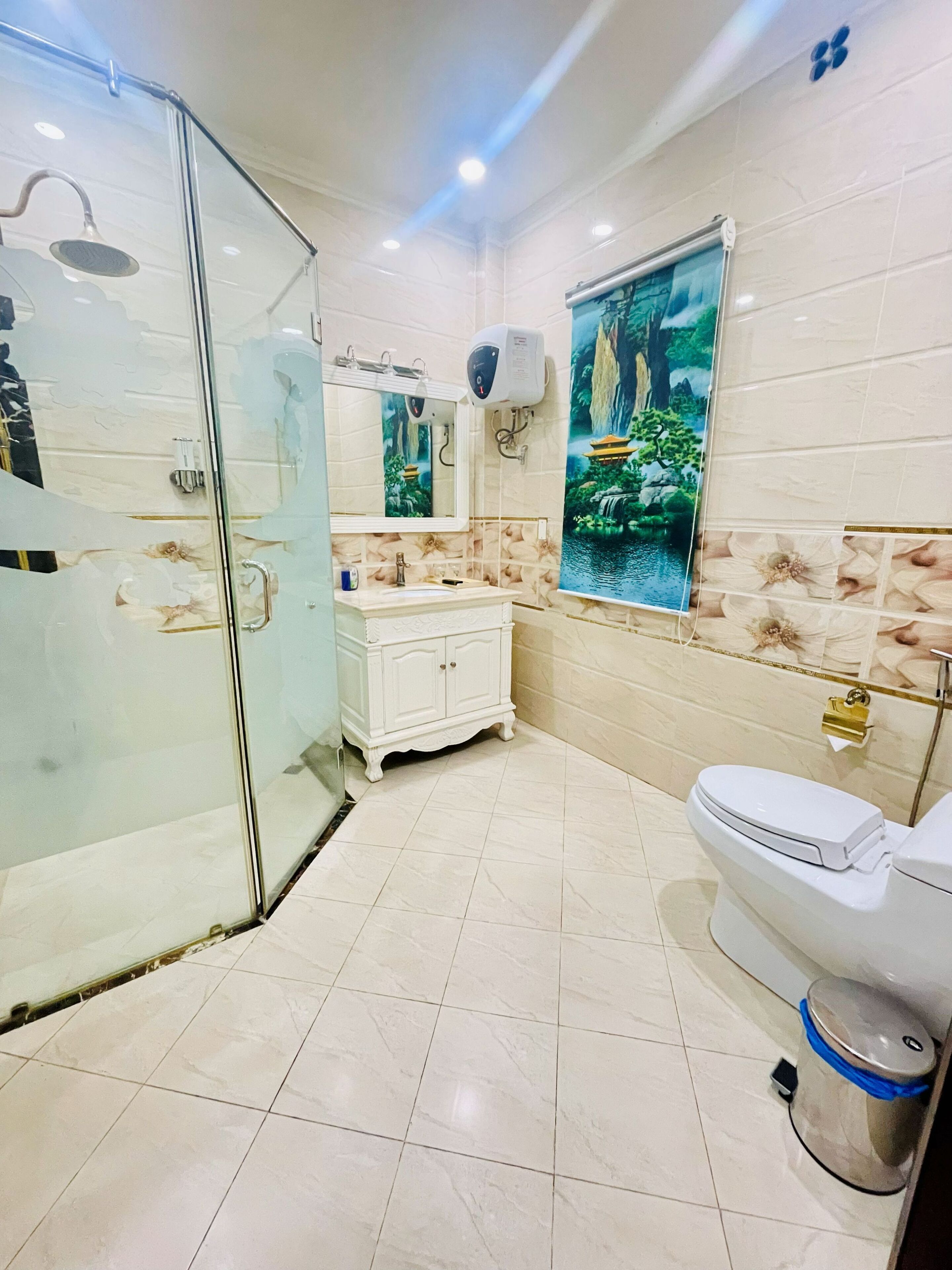Un baño moderno con cabina de ducha de vidrio, inodoro blanco y tocador con lavabo.