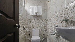 Une salle de bain avec des toilettes, un lavabo et des murs en marbre.