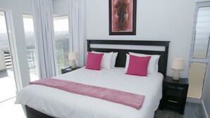 A hotel room with a large bed, a view of the city, and a balcony. - 6 Barquentine (Knysna)