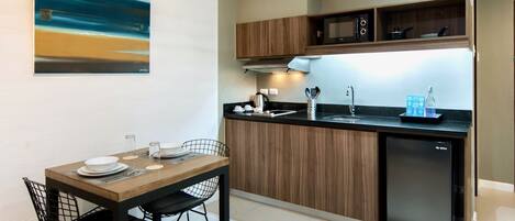 A compact kitchen with wooden cabinets, a black countertop, and a built-in dishwasher.