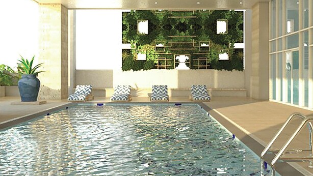 A swimming pool with a view of a green wall and a seating area with chairs. - The Sphere Serviced Residences Managed by HII (Makati)