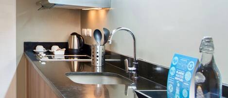 Une cuisine moderne dotée d’appareils électroménagers en acier inoxydable, de meubles de rangement en bois et d’un lave-vaisselle encastré.