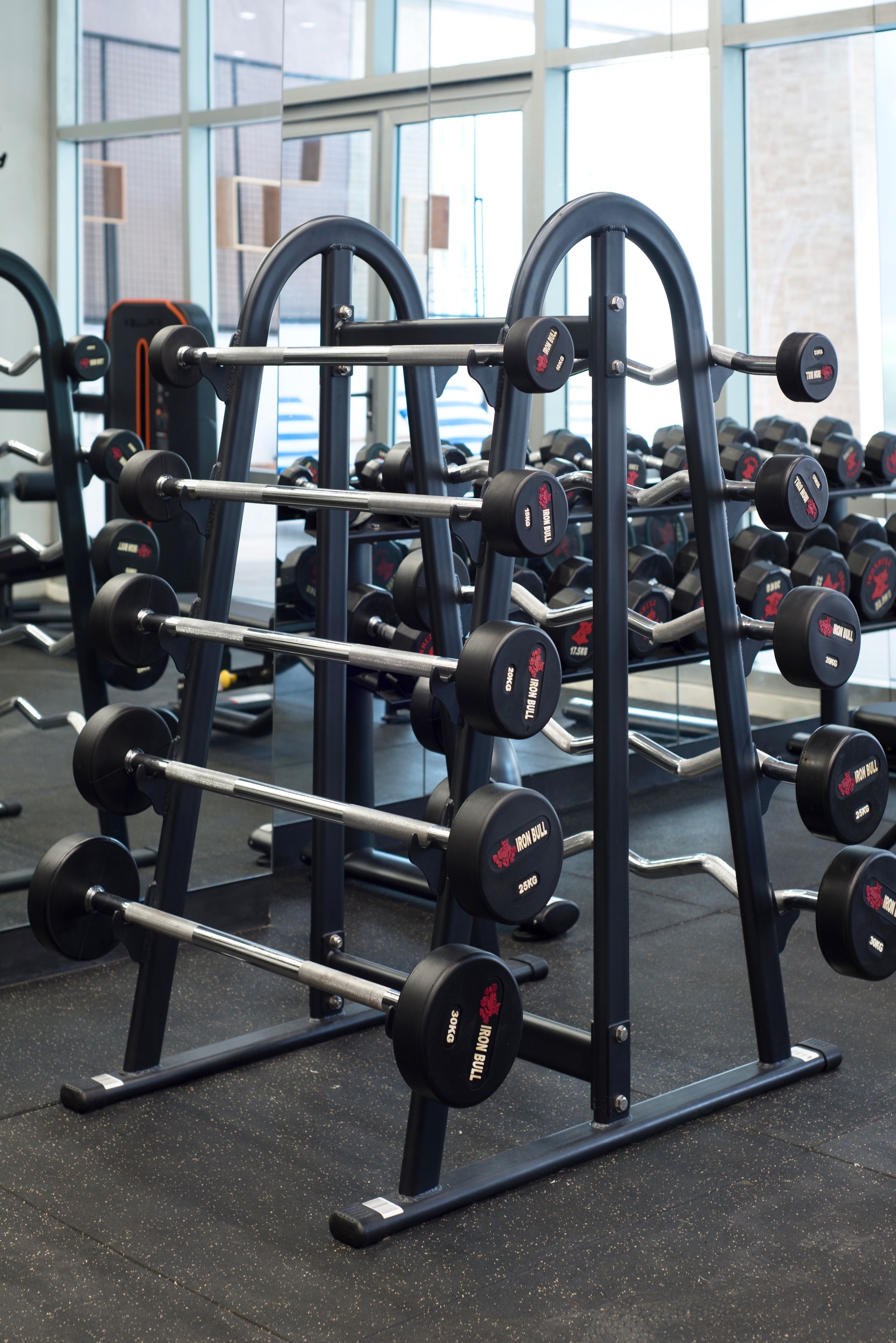 Une salle de sport équipée de matériel de musculation, notamment des barres et des haltères, disposés sur des supports.