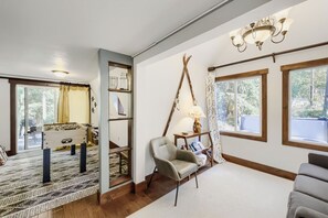 A room with a foosball table, a chair, a lamp, and large windows with curtains. - Free SkyCard Activi - Close To Town/Lifts, Private Hot Tub - High Point Chateau (Breckenridge)