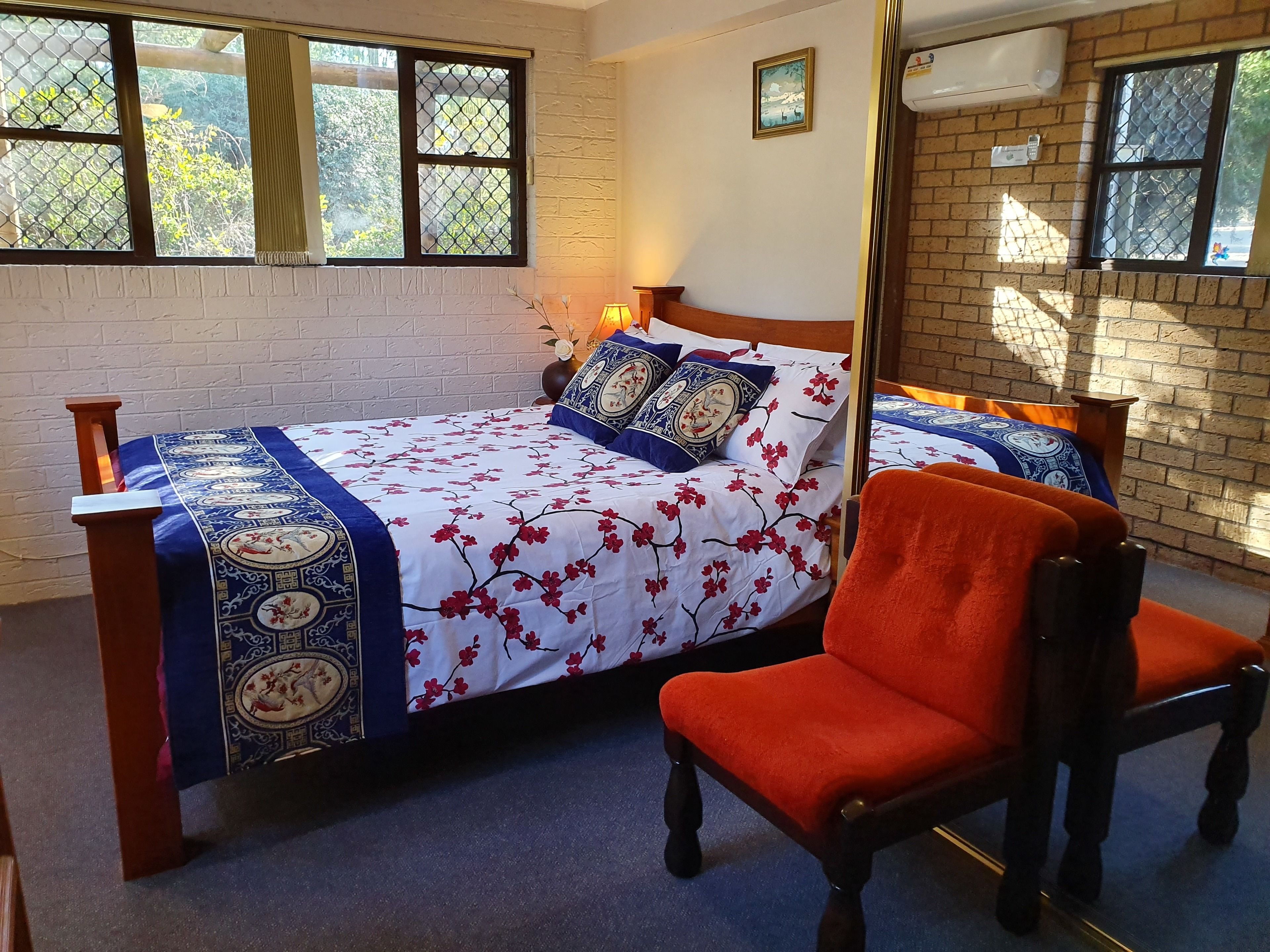 Un dormitorio con cama, una silla y una ventana.