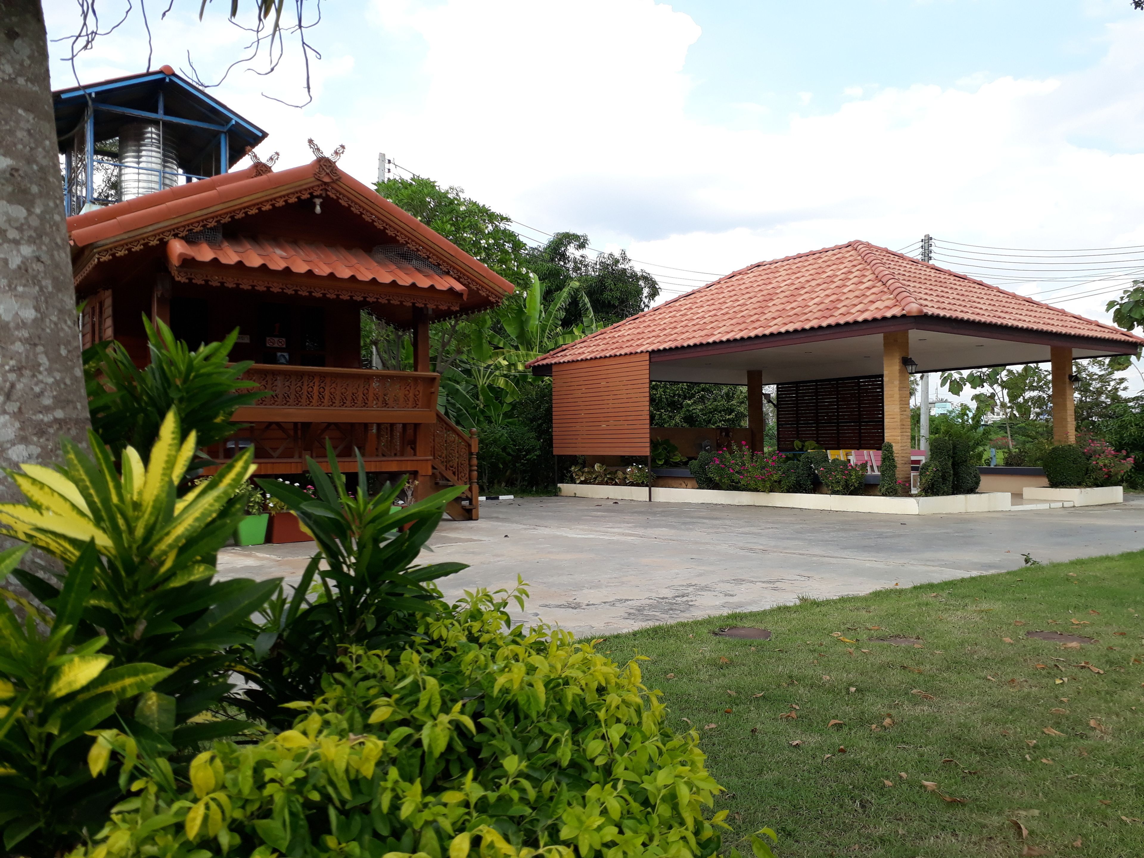 A building with a covered porch and a separate structure with a tiled roof.