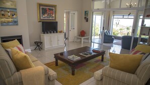 A living room with a sofa, coffee table, television, and artwork. - 20 Dunnage (Knysna)