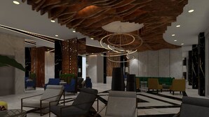 Um lobby moderno com poltronas de descanso, design de teto diferenciado e luminária central.