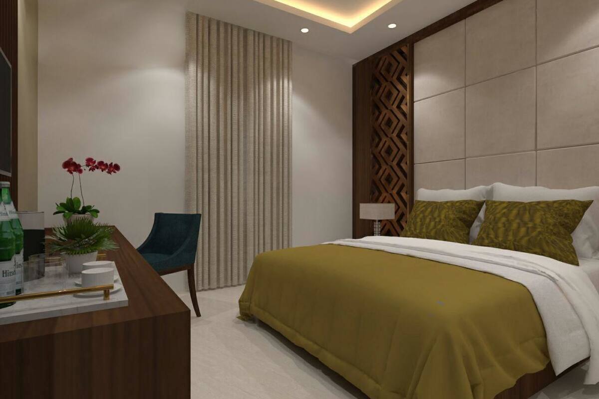 Habitación de hotel moderna con cama, escritorio, silla y una planta en maceta.