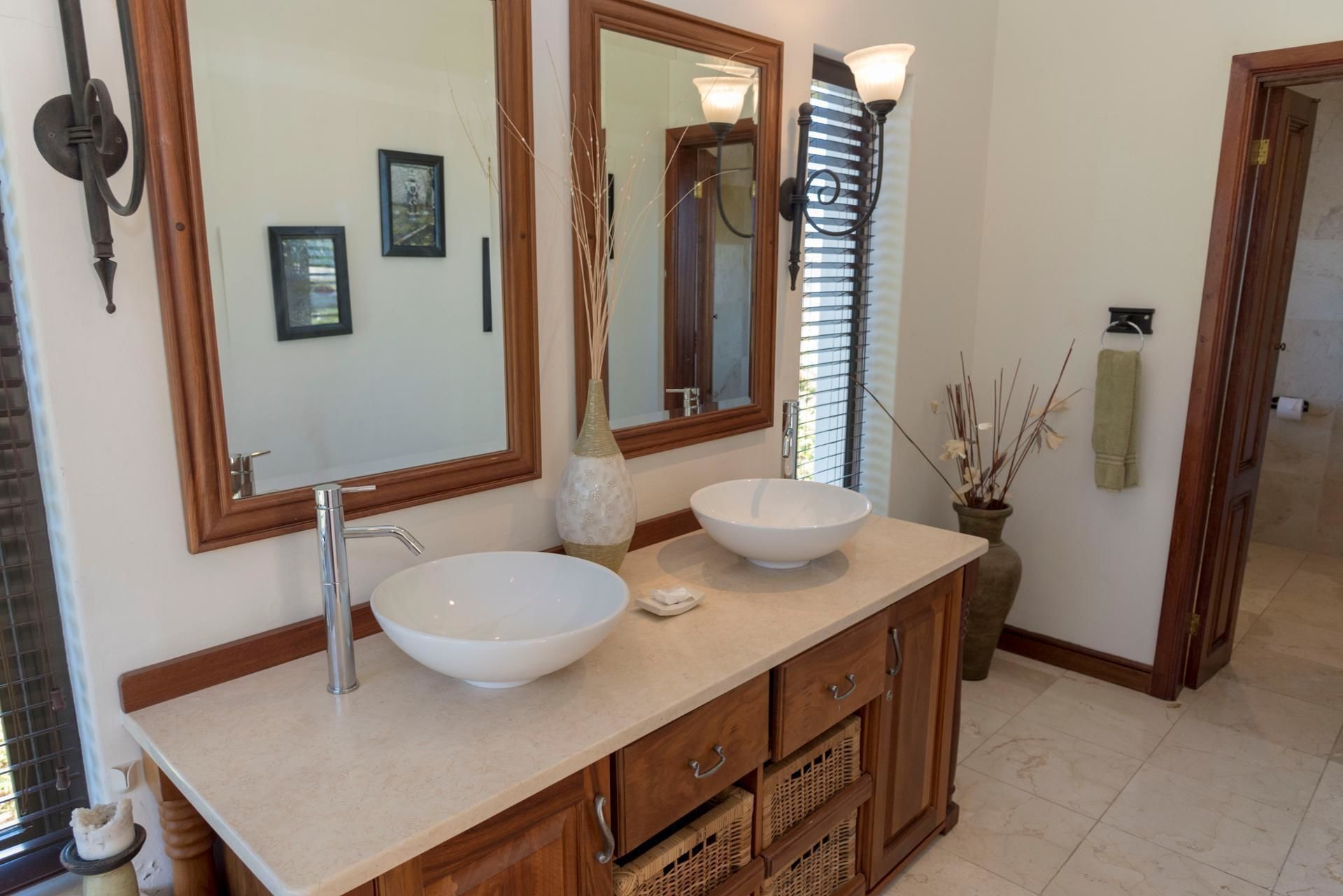 Une salle de bain avec deux lavabos, un grand miroir et des meubles en bois.