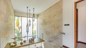 A modern interior with a wooden desk, decorative bird sculptures, and hanging light fixtures. - Villa Palavee B3 (Krabi)