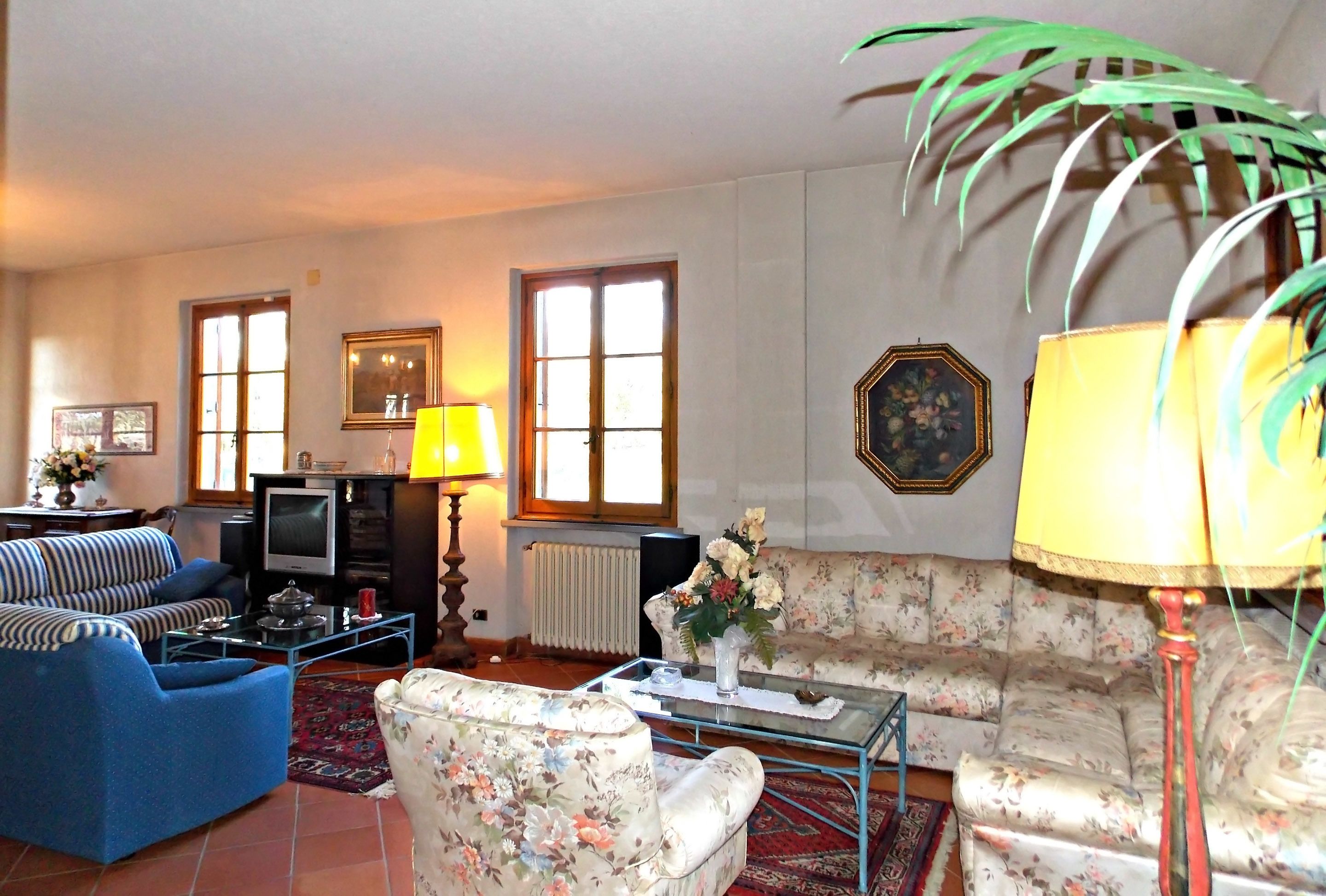 Un salon comprenant un canapé, un fauteuil, une table basse et un téléviseur.