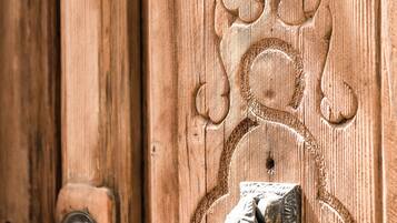 A wooden door with a metal knocker and a keyhole.