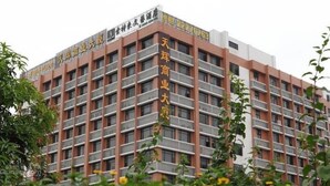 Ein mehrgeschossiges Gebäude mit modernem architektonischen Design, das eine Reihe von Fenstern und Balkonen aufweist.