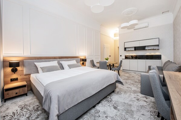 Ein modernes Hotelzimmer mit einem großen Bett, einem Schreibtisch und einer Sitzecke.