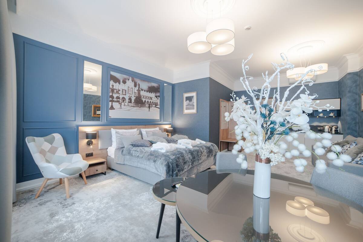 A modern bedroom with a bed, bedside tables, a chair, and a glass coffee table.