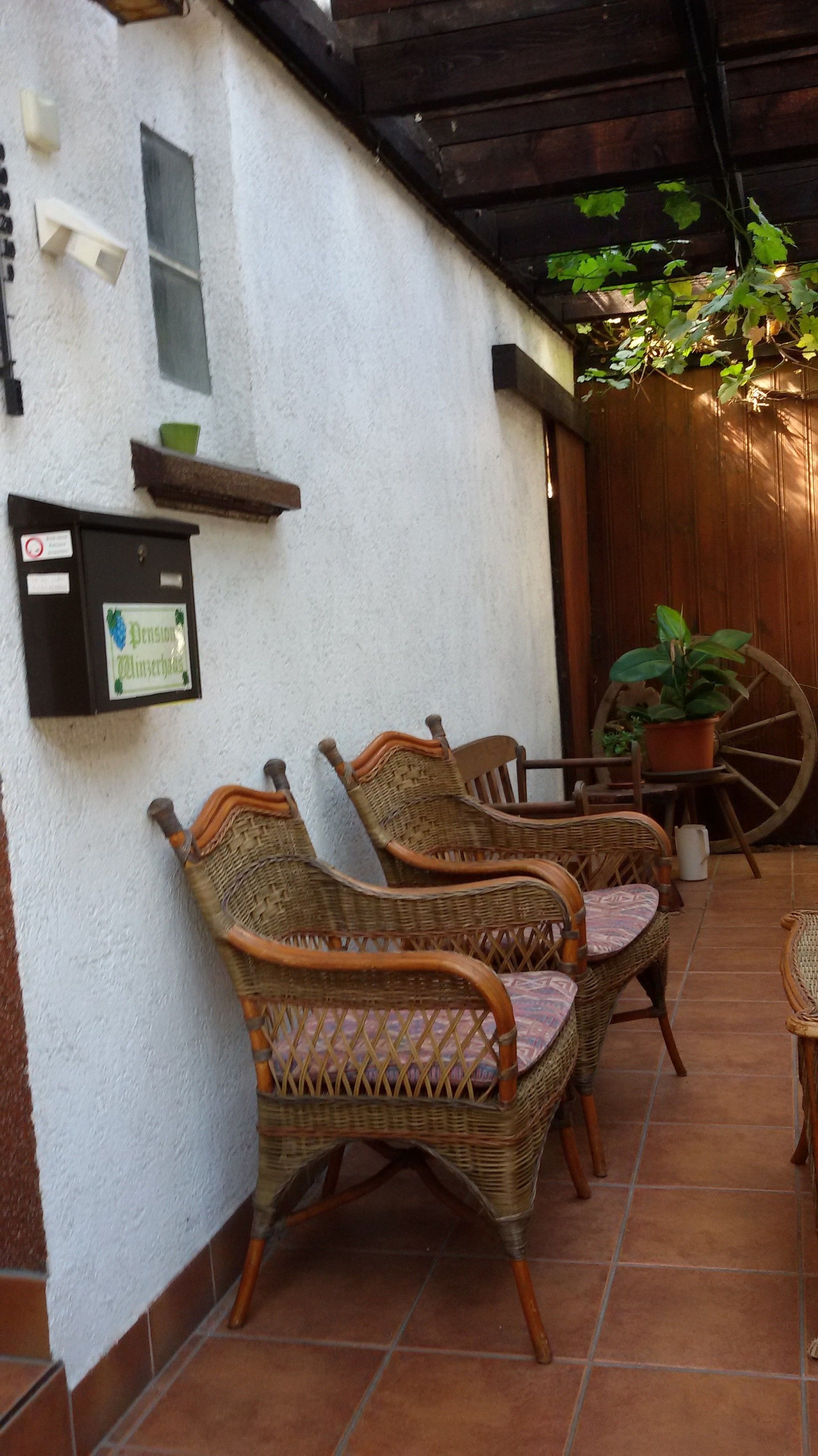 Wicker chairs with cushioned seats and backs, arranged on a tiled patio.