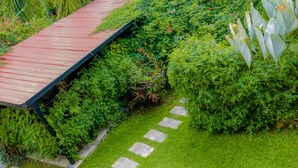 A garden pathway with a wooden deck and stone steps. - Select Boutique Hotel (Kigali)
