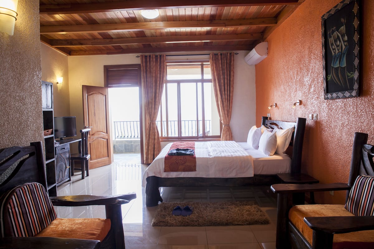A hotel room with a bed, a TV, a desk, and a chair.