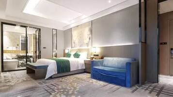 Una habitació d'hotel moderna amb un llit, un sofà blau, un escriptori i un mirall gran.