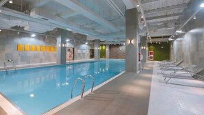 An indoor swimming pool with clear lanes, a tiled floor, and a glass wall on one side. - Courtyard by Marriott Hangzhou Xiaoshan (Hangzhou)