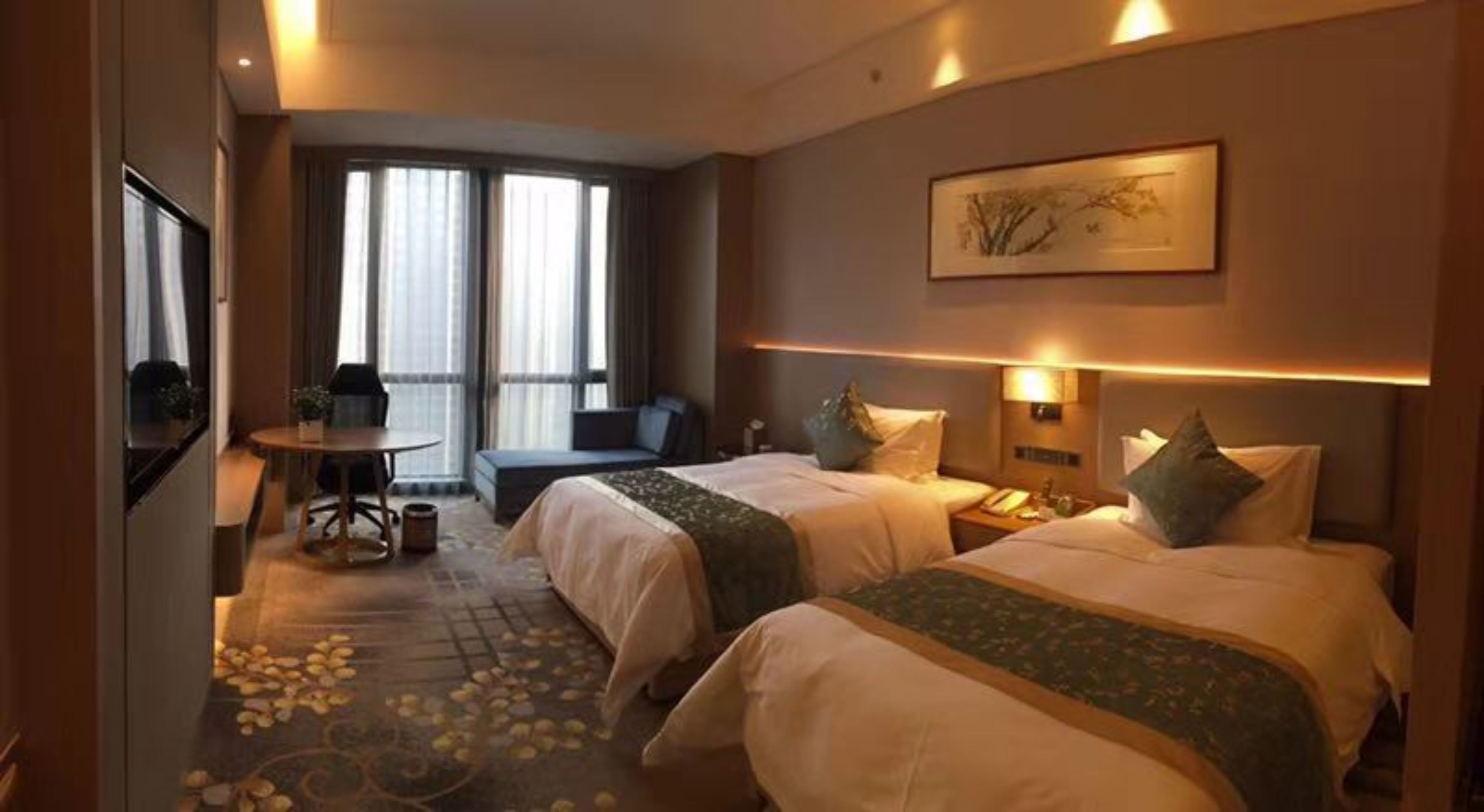 Une chambre d’hôtel avec deux lits, un bureau, une chaise, un canapé et une grande fenêtre.