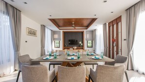 A dining room with a large table set for six, surrounded by six chairs. - Villa Palavee A2 (Krabi)
