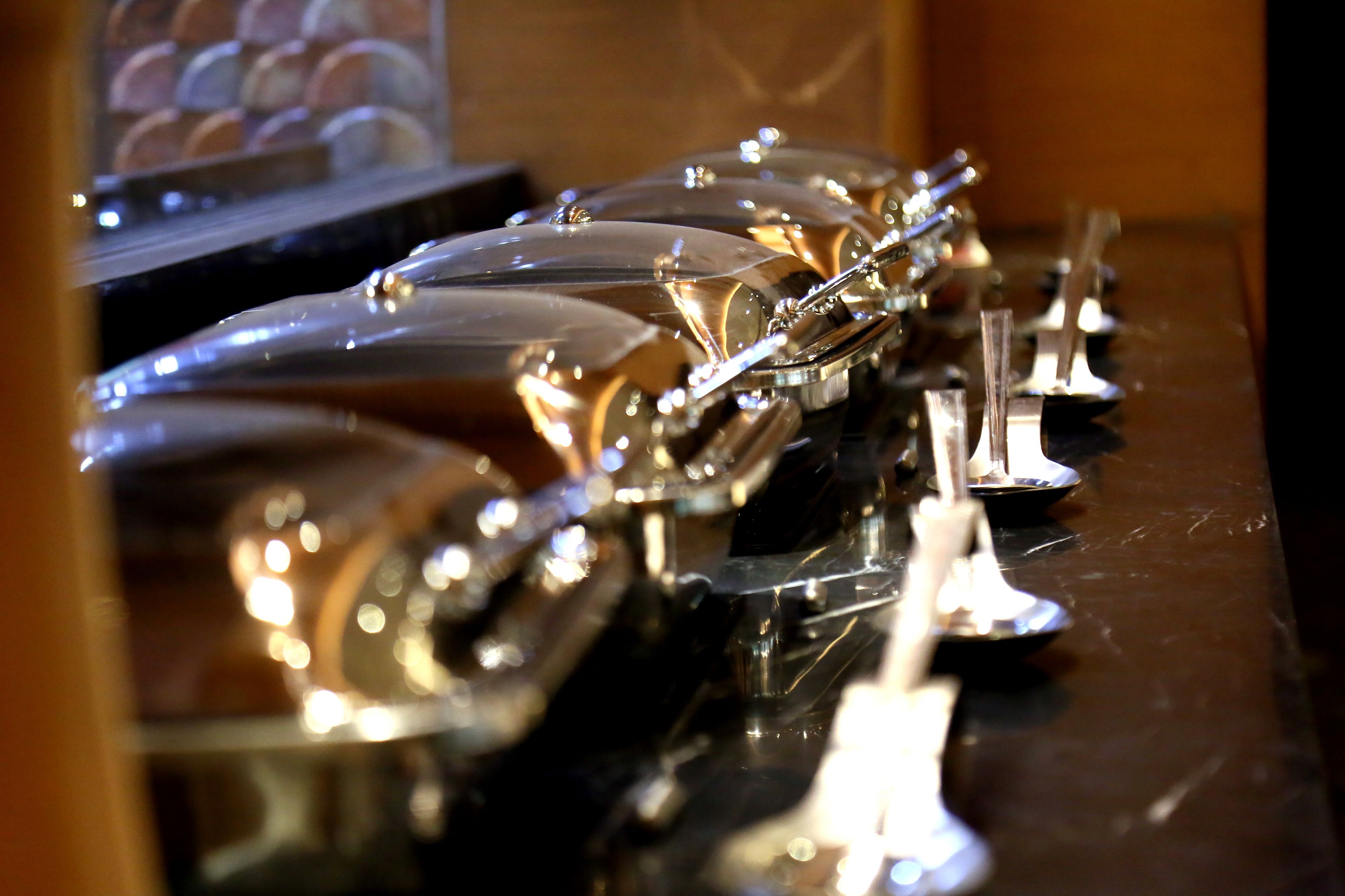 A row of shiny, metallic objects on a reflective surface.