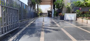 Un sendero pavimentado que conduce a una entrada con portón, con un letrero que indica F. RITUNE AVENUE, parte del grupo hotelero ITC.
