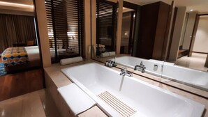 Un baño moderno con una bañera grande, un espejo y una zona de ducha.