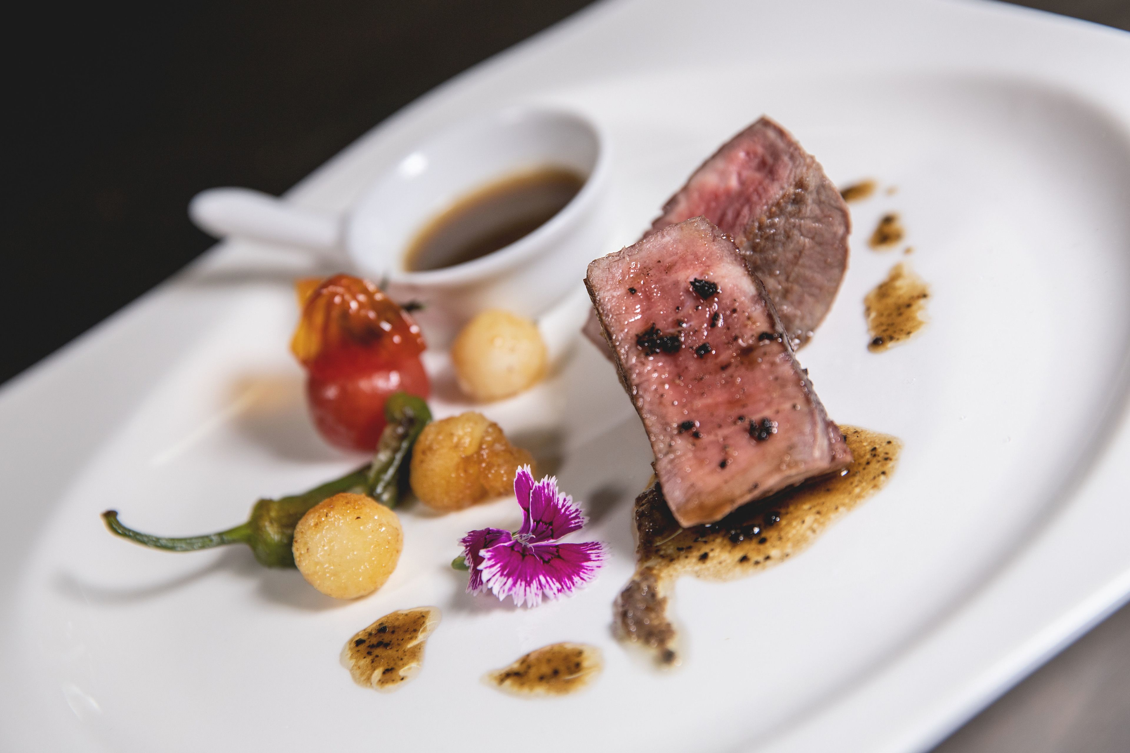 Un piatto con una bistecca, verdure e salsa.