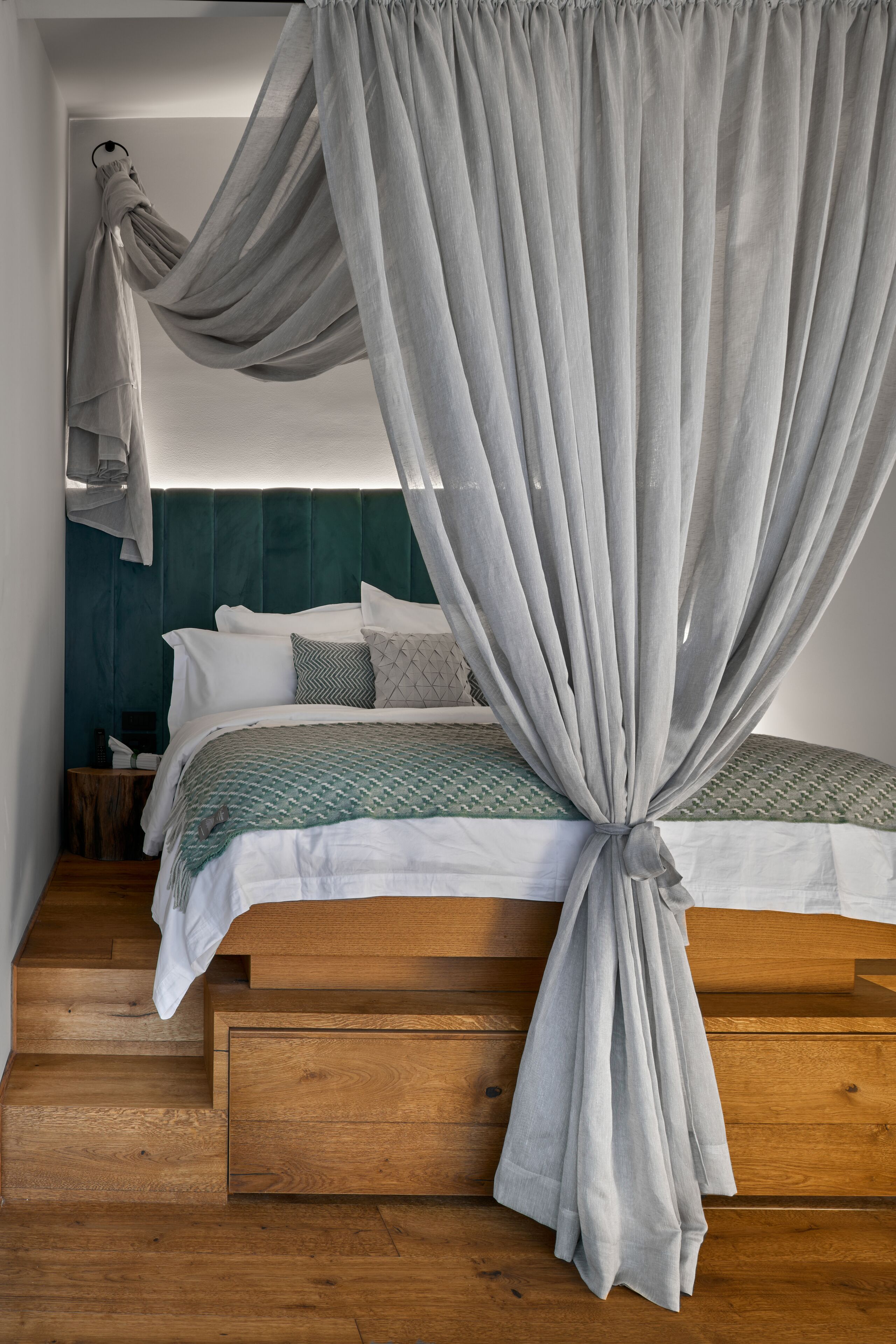 Une chambre à coucher avec un lit, un banc en bois et une table de chevet.