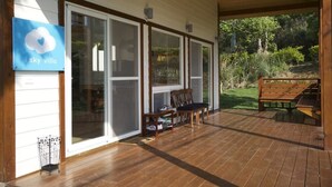 A wooden deck with a bench and chairs, a sign reading "i sky villa," and a view of the surrounding greenery. - I Sky Villa (Zaoqiao)