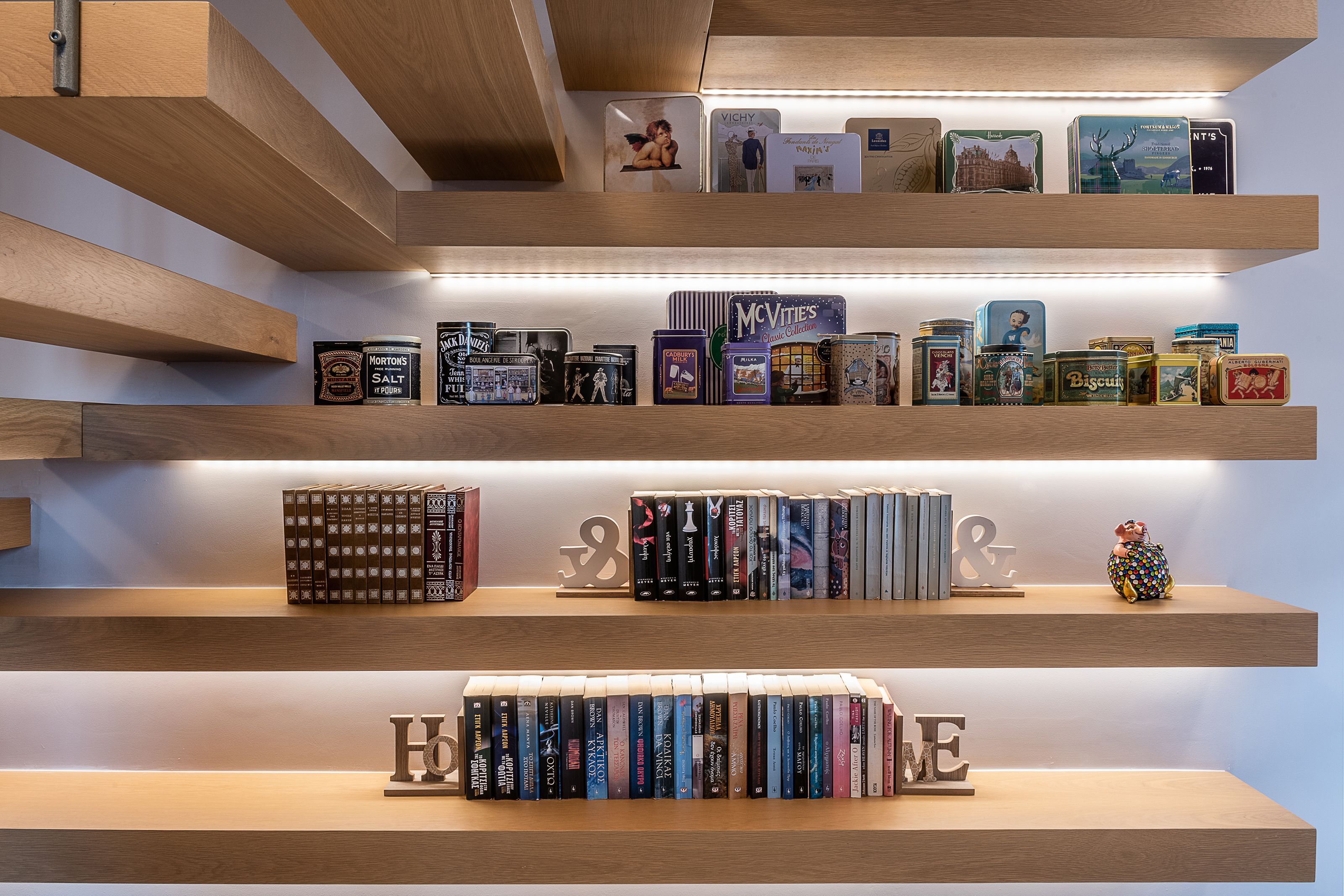 A bookshelf with books and tins.