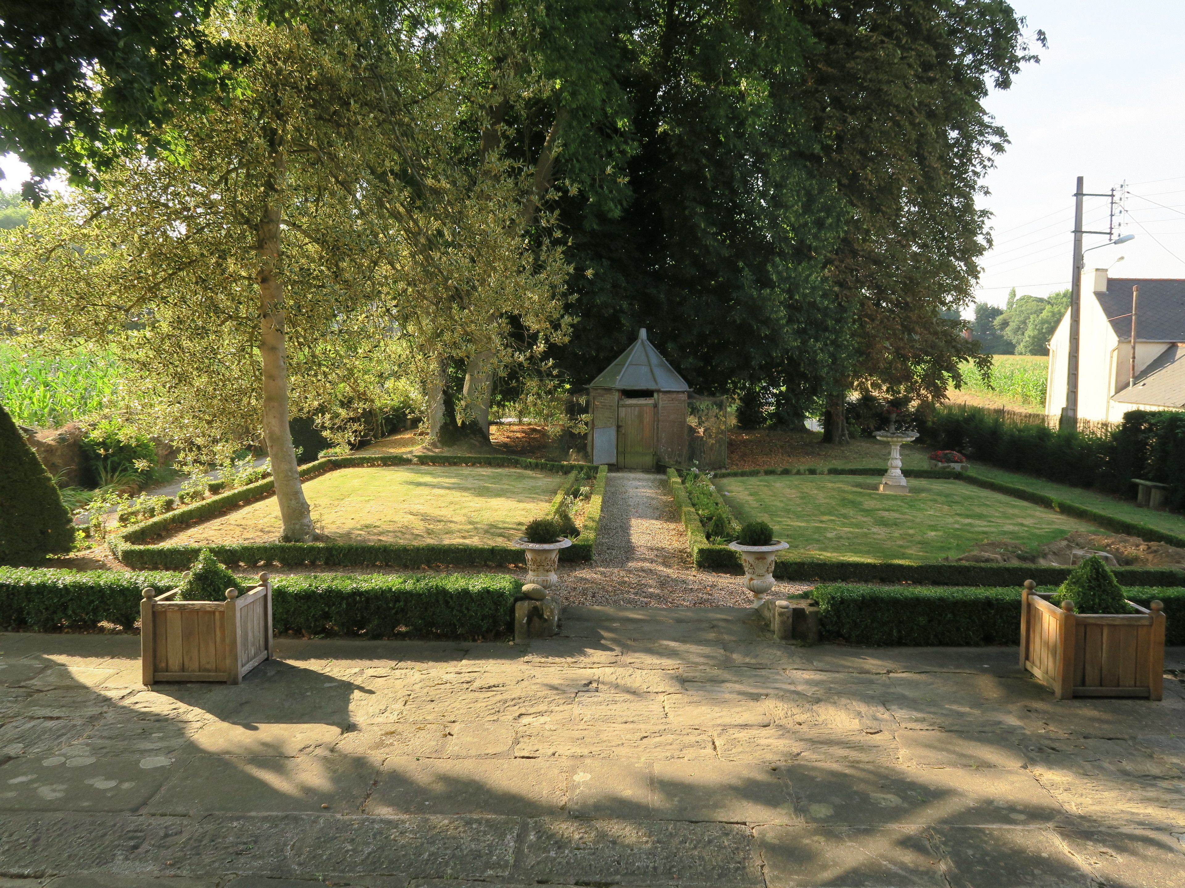 Un giardino curato con un vialetto in pietra che conduce a una struttura in legno.