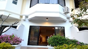 A two-story house with a balcony, a staircase, and a garden with various plants. - Sila Pool Villa (Mae Rim)