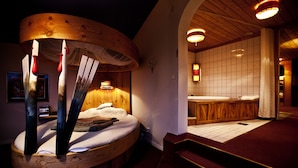 Une pièce chaleureuse avec un lit rond en bois, un plafond en bois et un mur recouvert de carreaux.
