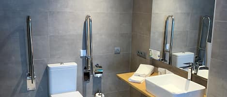 Un baño moderno con inodoro, bidé y lavamanos.