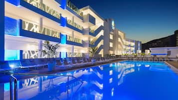 Una piscina al aire libre, sombrillas, tumbonas