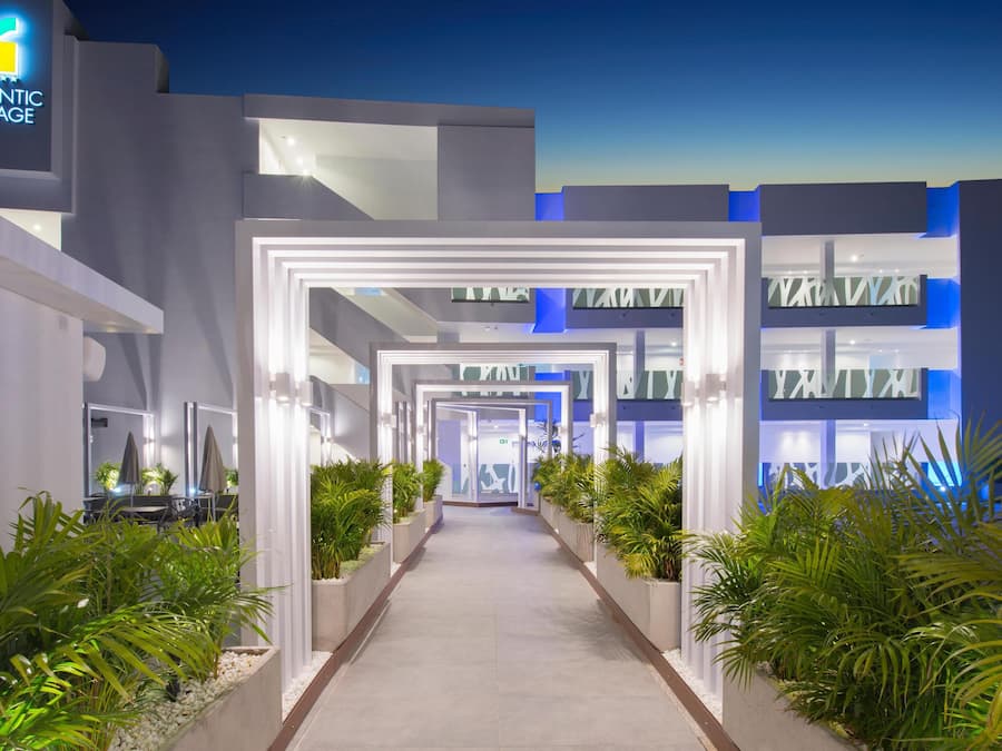 Un edificio moderno con un paseo central bordeado por macetas y un letrero que dice "ATLANTIC MIRAGE".